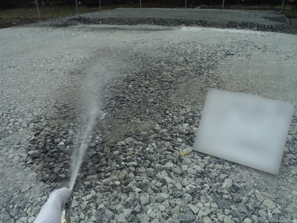 土壌処理。基礎工事前に、シロアリ予防の薬剤を土壌に撒く写真。