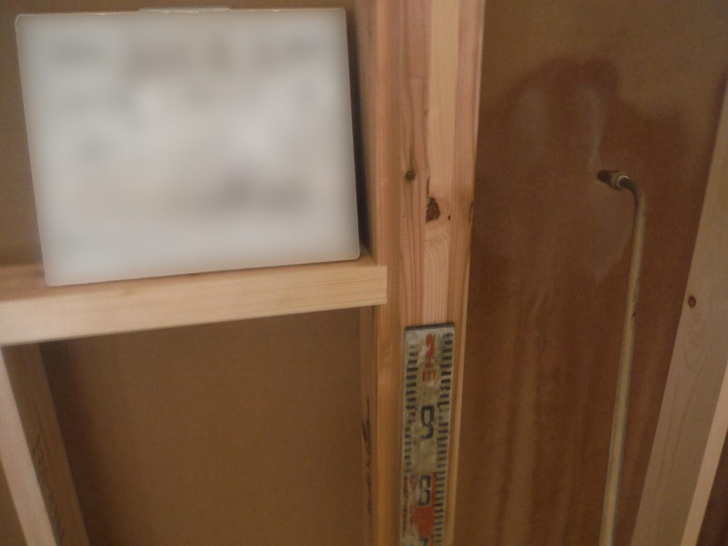 シロアリ木部処理の写真。外壁と内壁の間にある壁（耐力壁）に防蟻薬材を噴霧する様子。